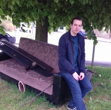 Ross Archer on a discarded sofa